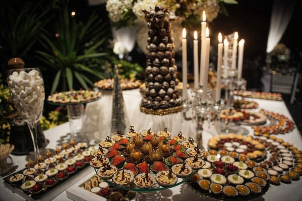 Mesa de postres con velas y decoración floral