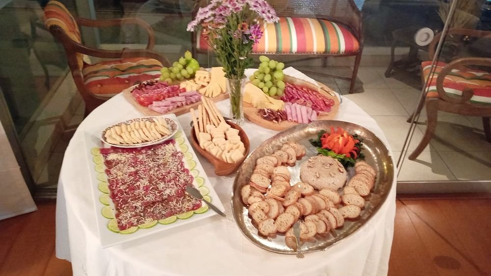 Tabla de quesos y embutidos sobre una mesa decorada con flores