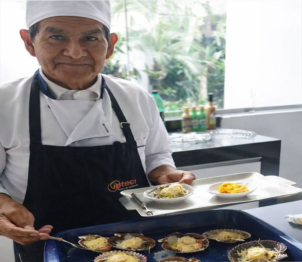 El chef Andrés Gonzales presentando un plato de conchas