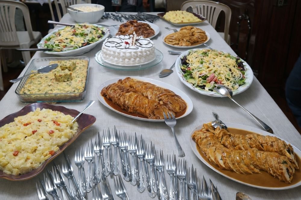 Mesa servida con platos variados y torta para una celebración familiar