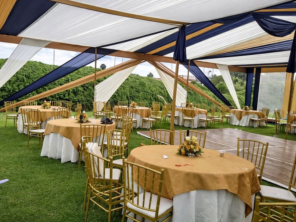 Carpa decorada con mesas doradas lista para un evento